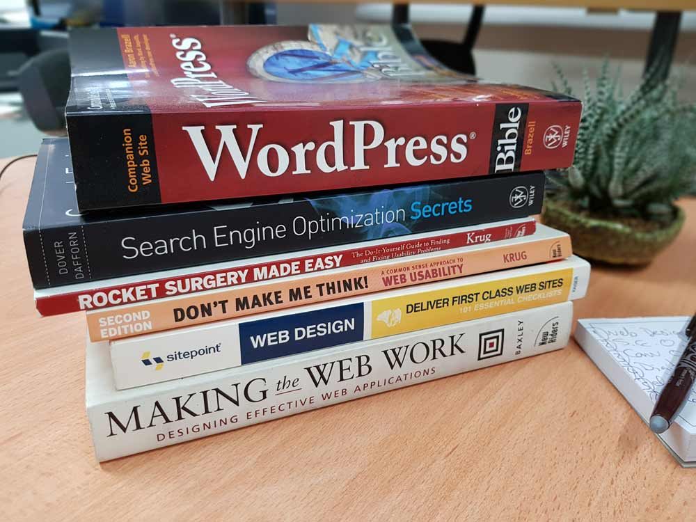 Stack of SEO and web design books on a desk